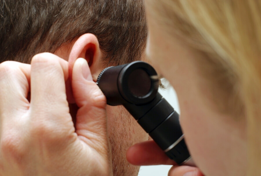 A woman inspecting a man's ear