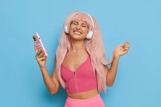 Woman enjoying music, smiling.