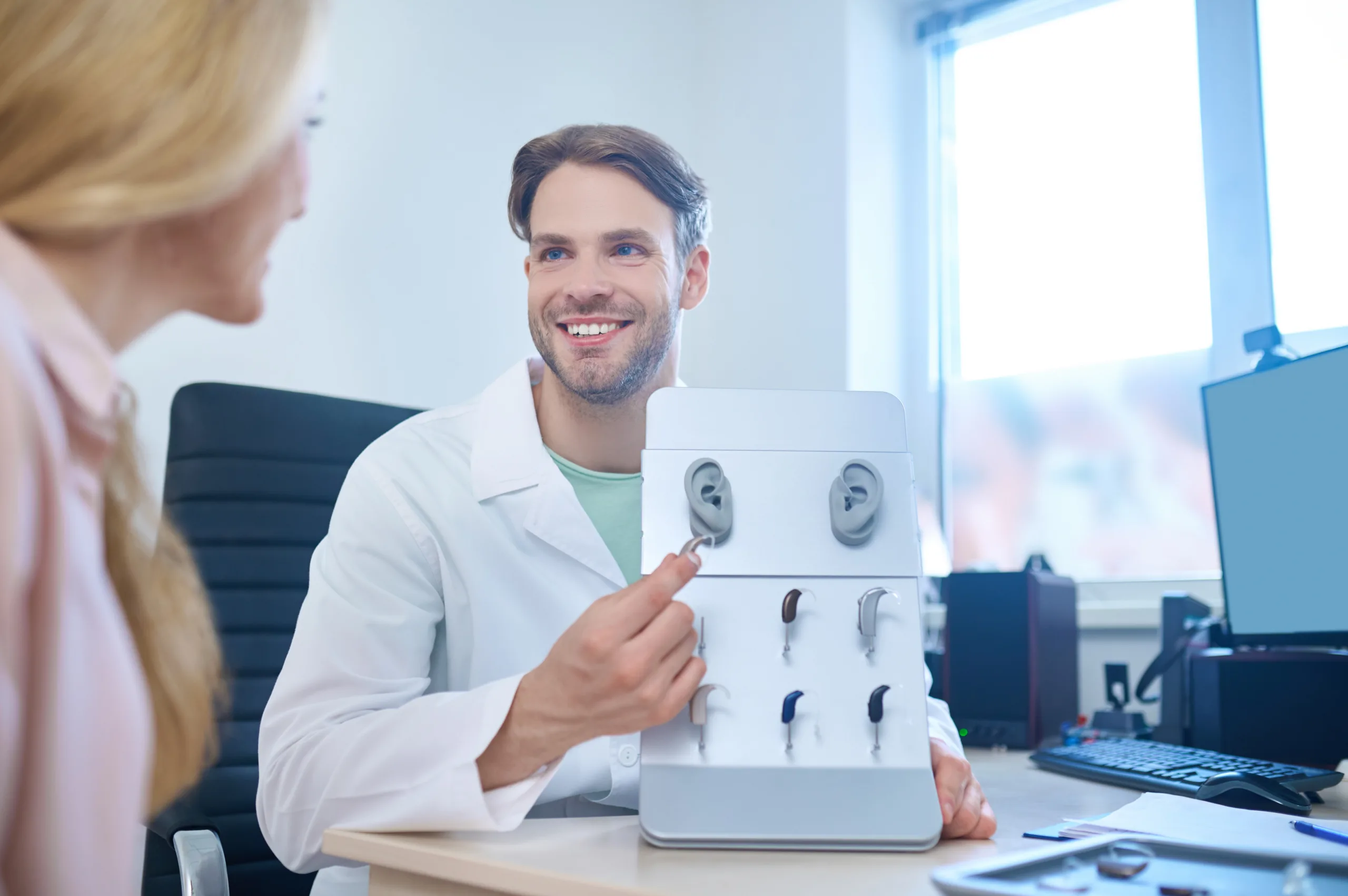 Doctor showing hearing aids display.