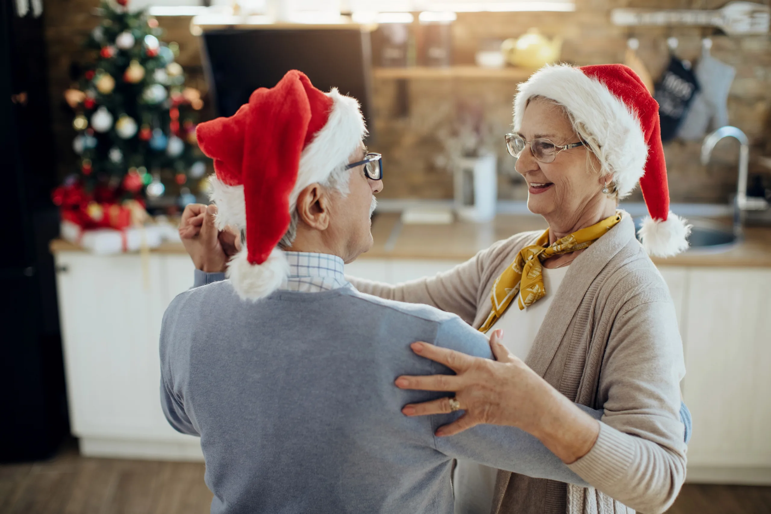 Elderly couple dancing, Christmas hats.