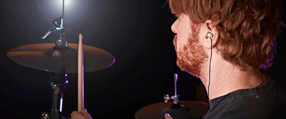 Drummer playing cymbals, wearing earplugs