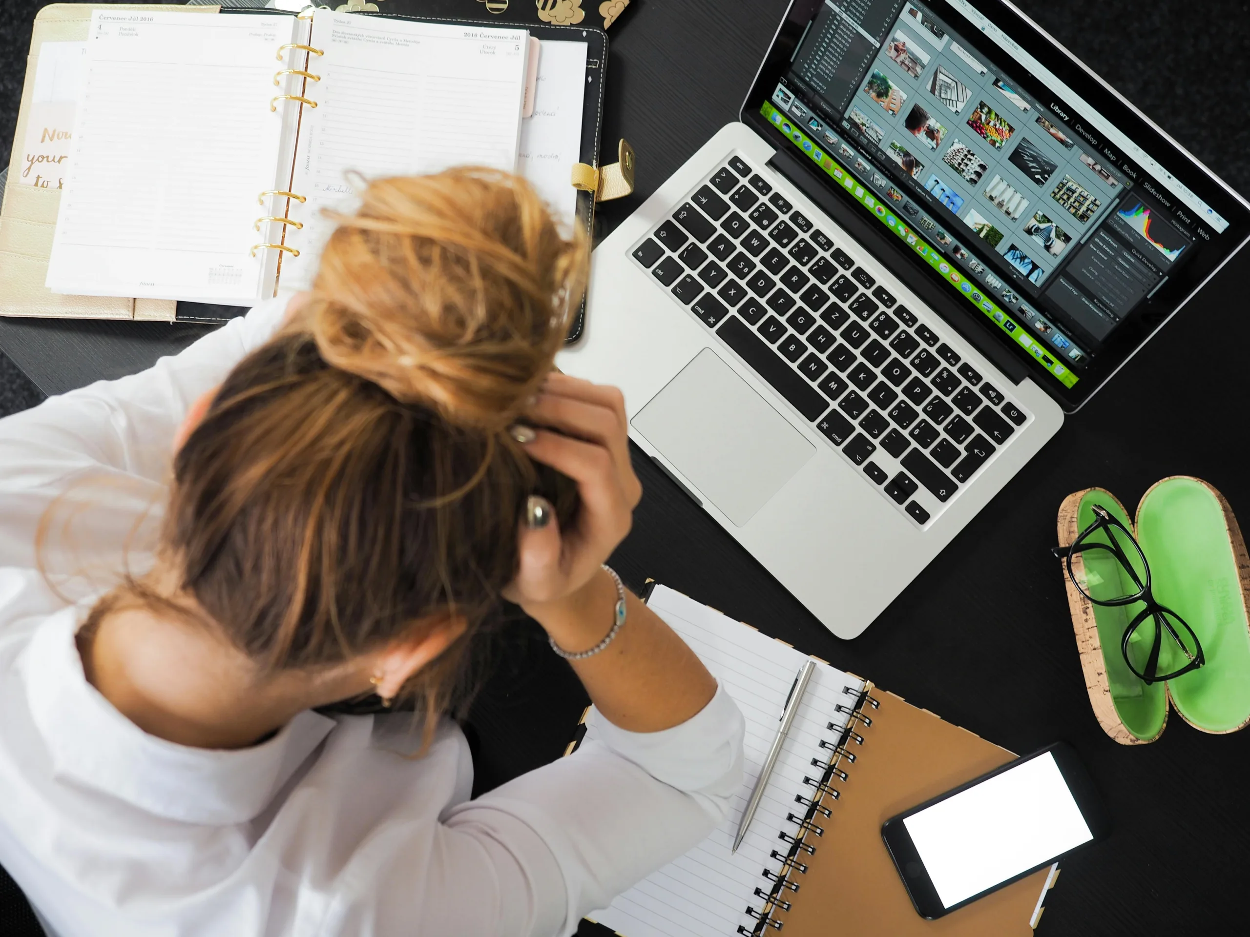 Stressed woman at laptop desk.