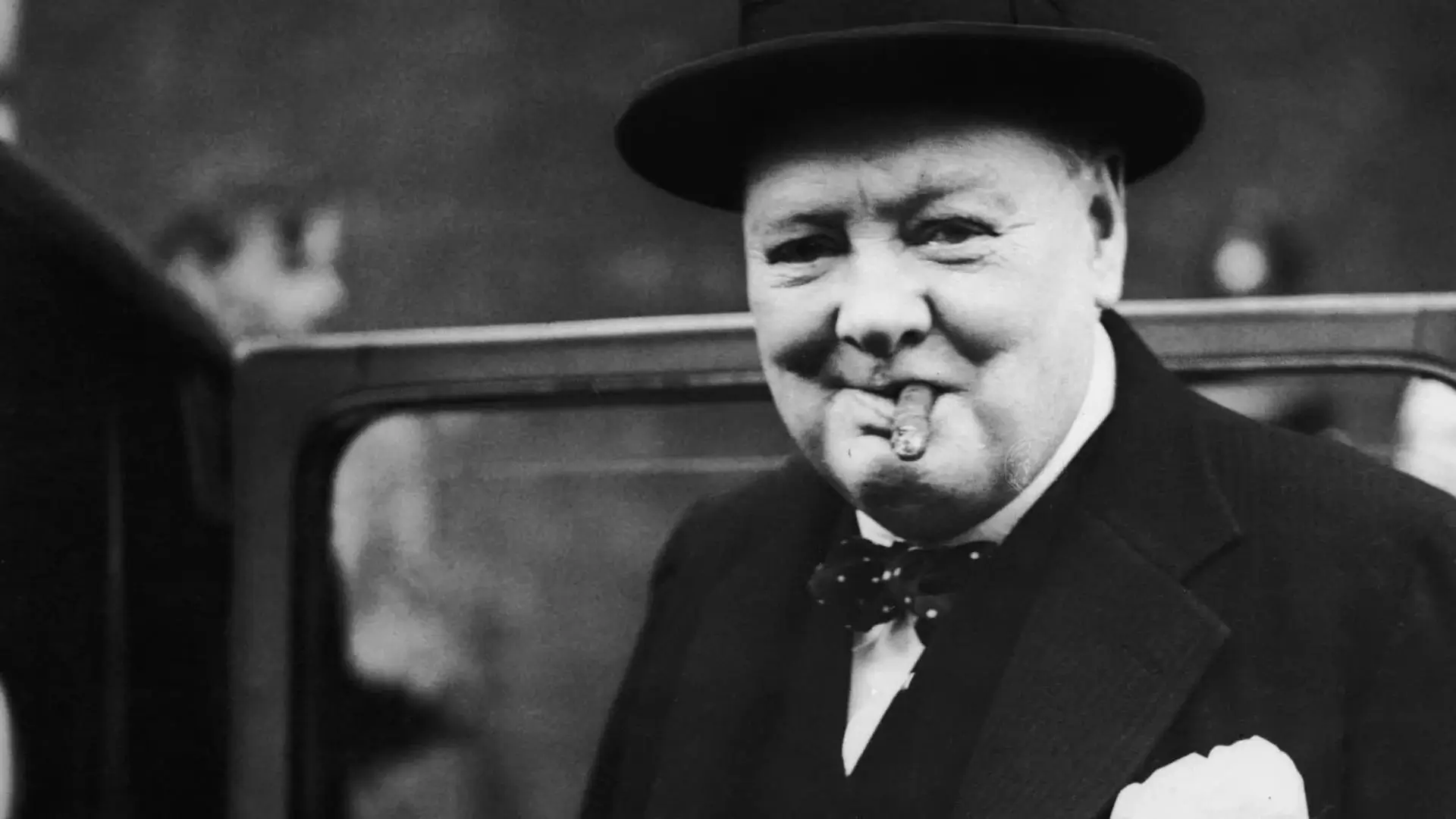 Man with cigar, wearing hat.