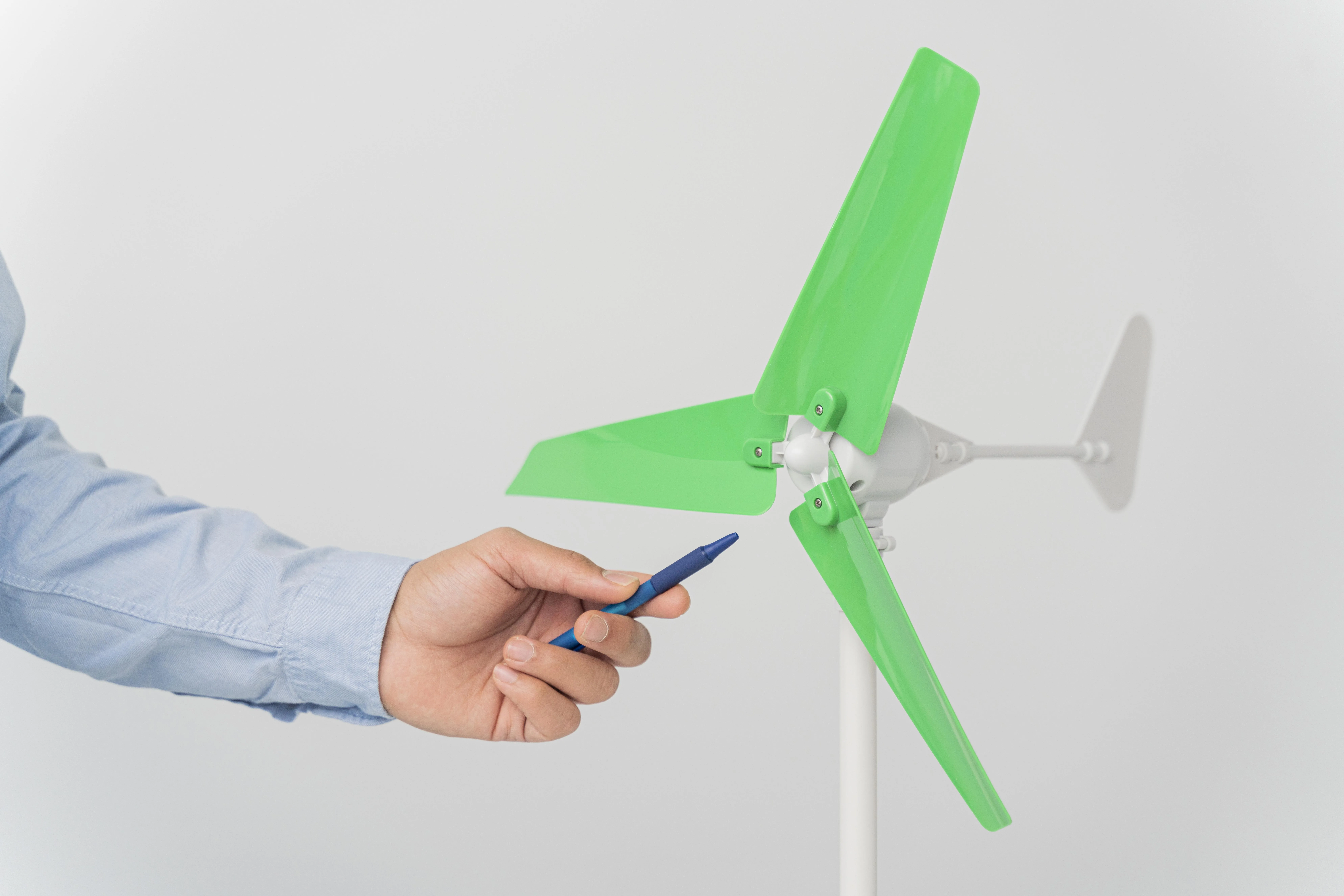 Hand examining green wind turbine