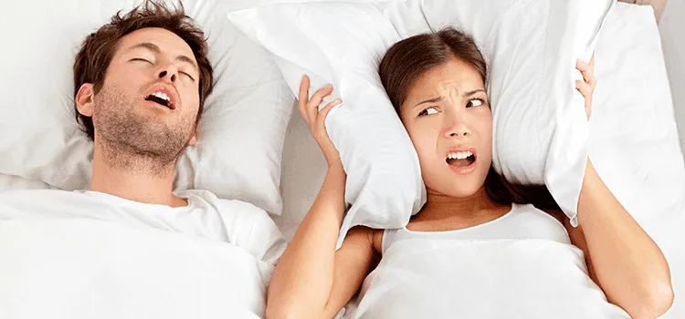 Woman annoyed by snoring partner.