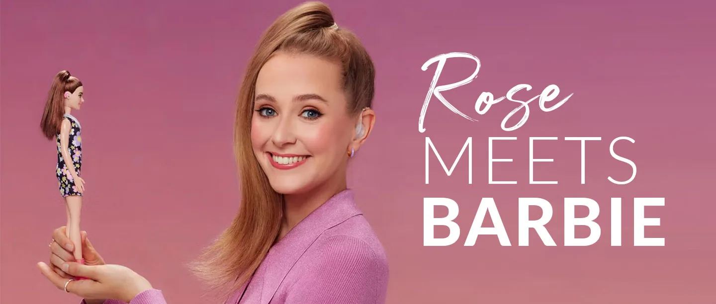 Smiling woman holding Barbie.