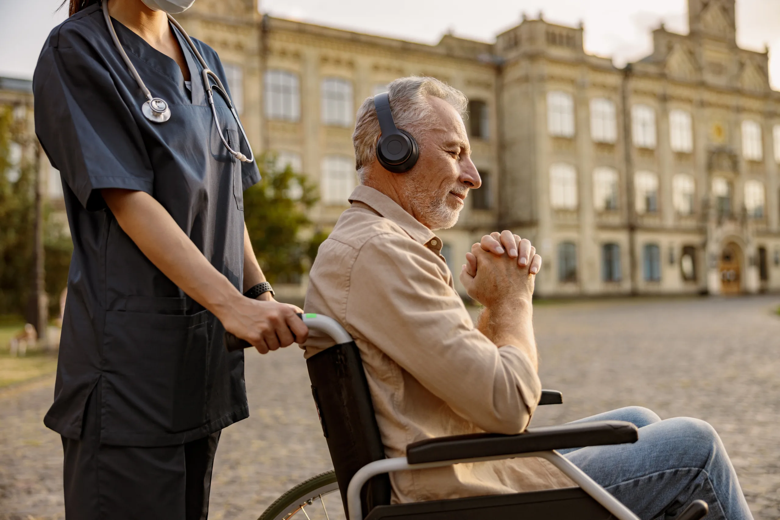 Man in wheelchair wearing headphones.