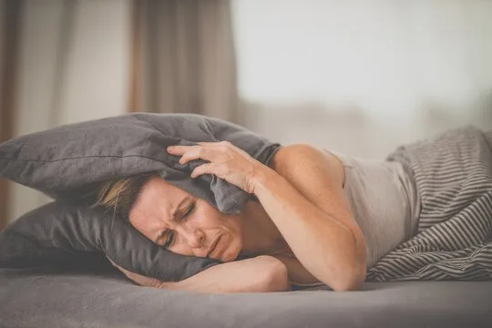 Woman covering ears pillow