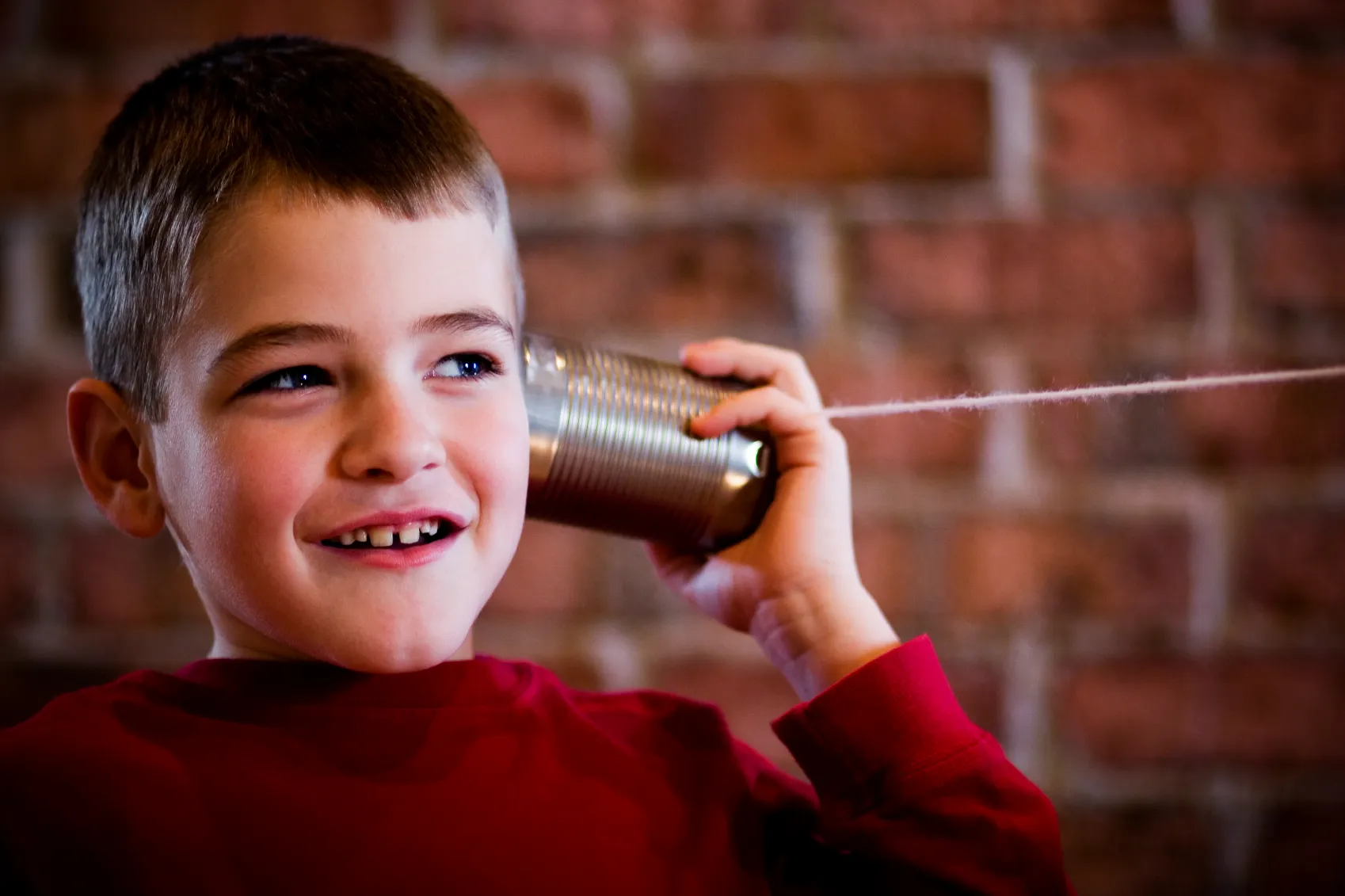 Child using tin can telephone.